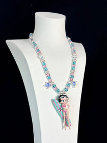 Close-up of a handmade pink Swarovski crystal charm necklace with crystals, pearls and surf-inspired collectible charm details