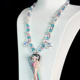 Close-up of a handmade pink Swarovski crystal charm necklace with crystals, pearls and surf-inspired collectible charm details