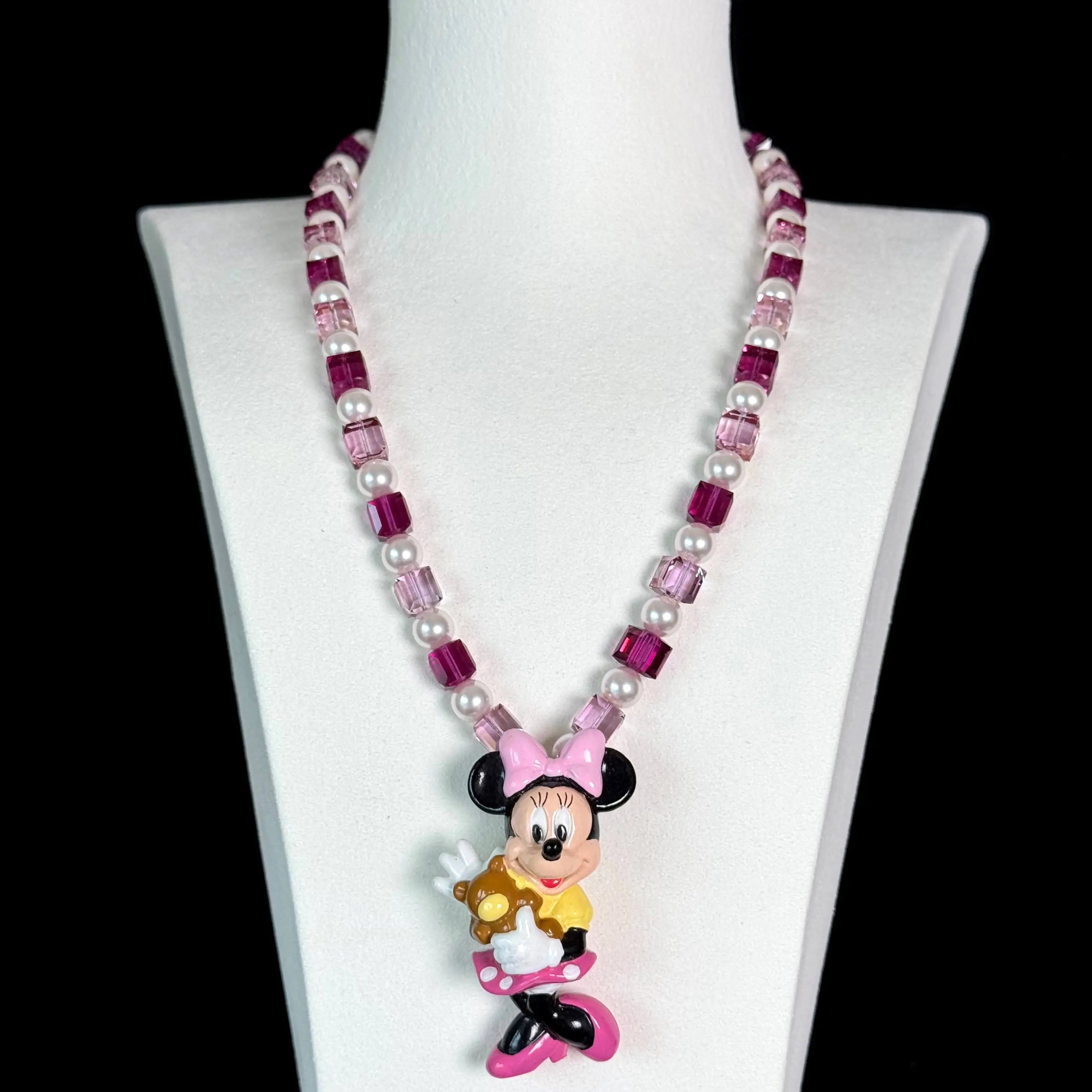 Close-up of a handmade pink Swarovski crystal charm necklace with crystals, pearls and sweetheart-inspired collectible charm details
