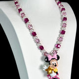 Model wearing a handmade pink Swarovski crystal charm necklace with crystals, pearls and sweetheart-inspired collectible charm details