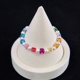 Model wearing a handmade rainbow Swarovski crystal charm bracelet with crystals, pearls and rainbow-inspired collectible charm details