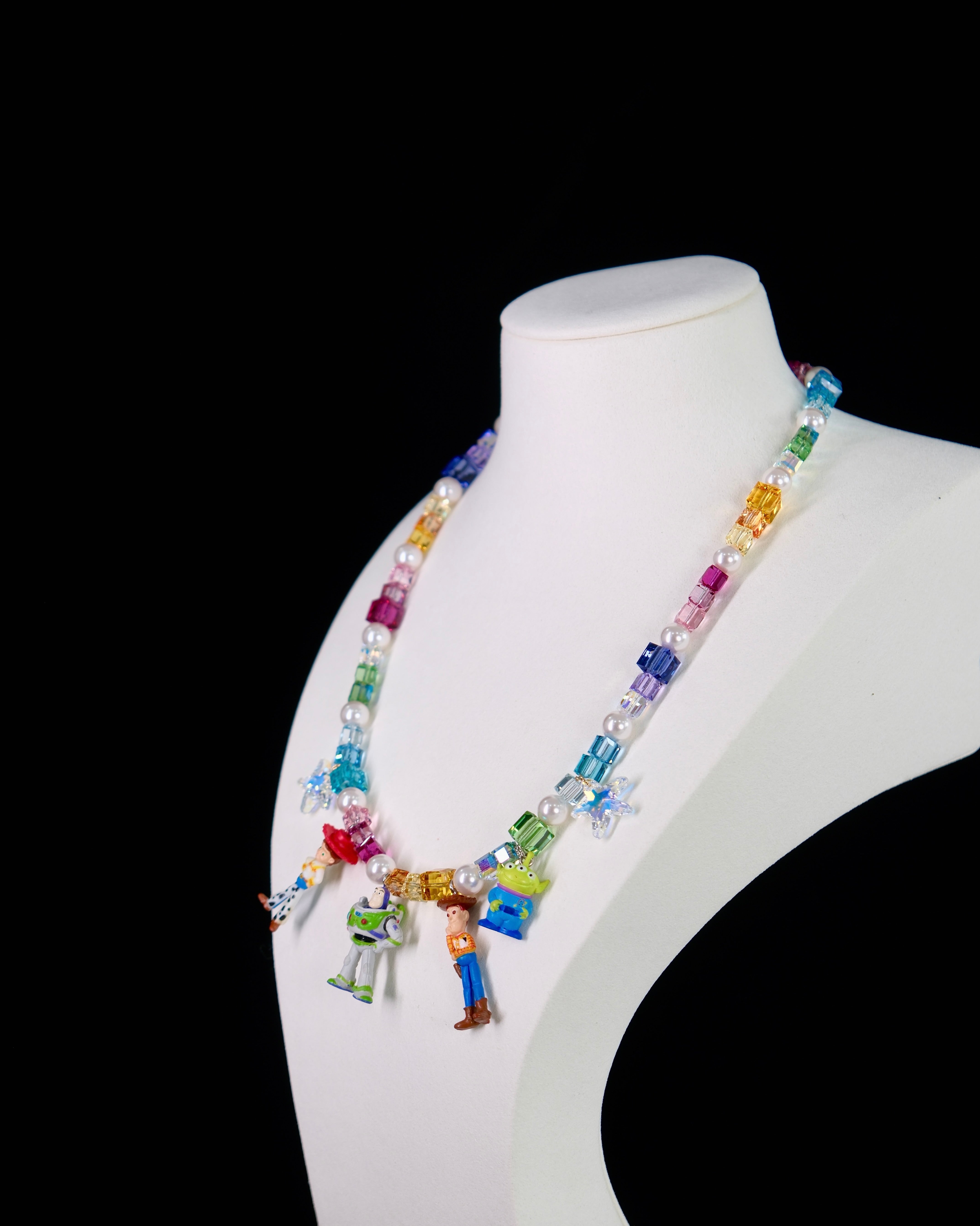 Close-up of a handmade rainbow Swarovski crystal charm necklace with crystals, pearls and rainbow-inspired collectible charm details