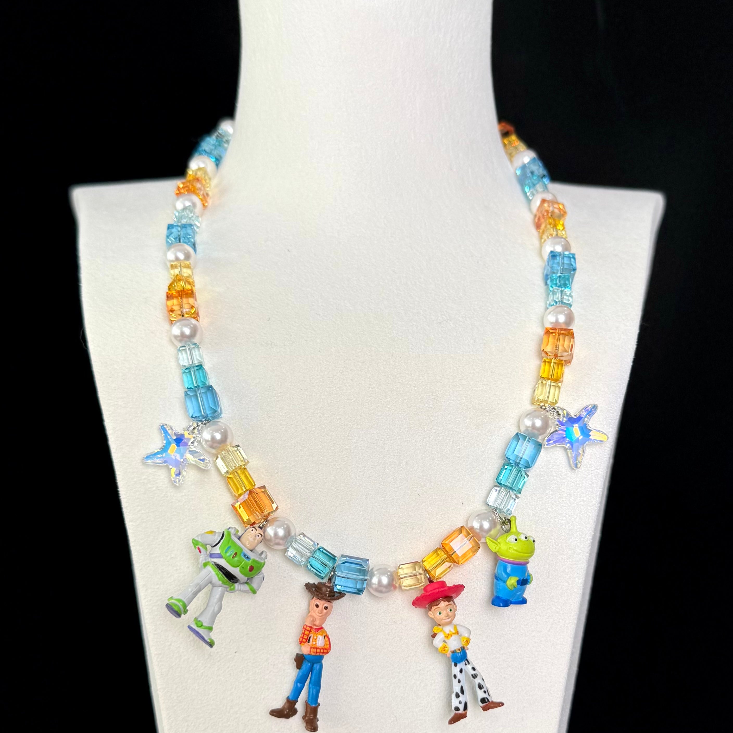 Close-up of a handmade Swarovski crystal charm necklace with crystals, pearls and rainbow-inspired collectible charm details
