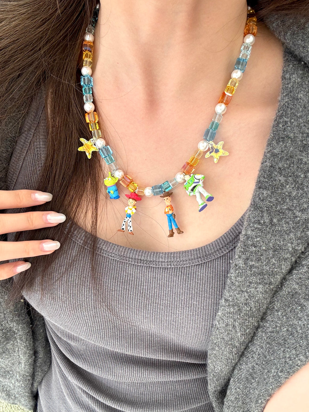 Model wearing a handmade Swarovski crystal charm necklace with crystals, pearls and rainbow-inspired collectible charm details