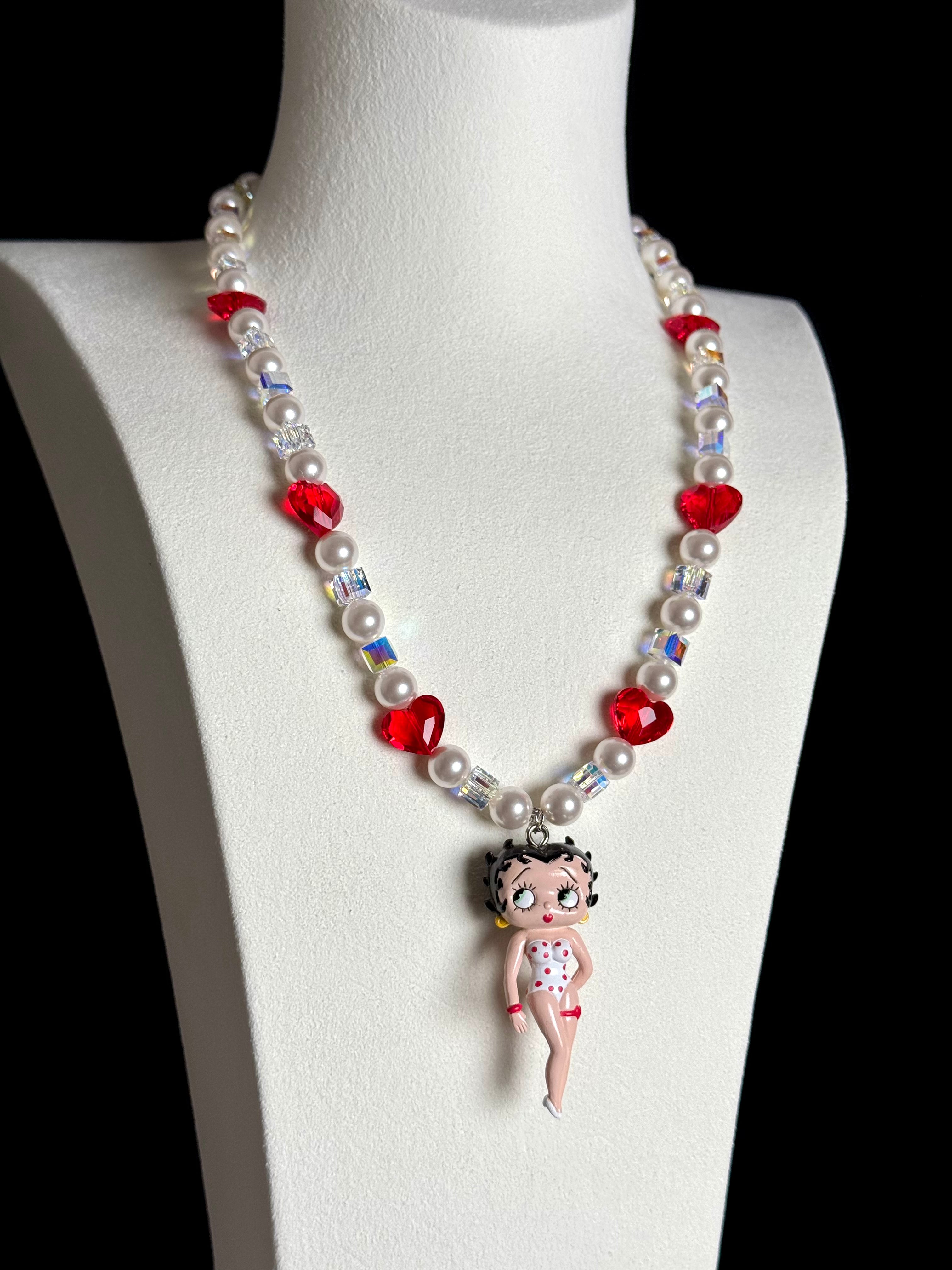 Close-up of a handmade red Swarovski crystal charm necklace with crystals, pearls and retro-inspired collectible charm details