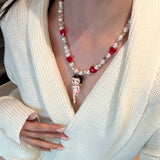 Model wearing a handmade red Swarovski crystal charm necklace with crystals, pearls and retro-inspired collectible charm details