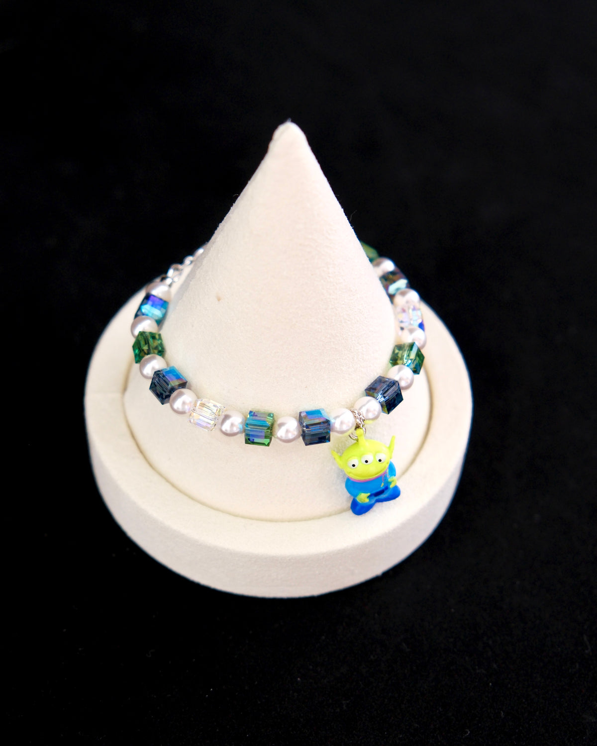 Side view of a handmade Swarovski crystal charm bracelet with layered crystals, pearls and cosmic-inspired collectible charm details