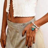 Model wearing a handmade Swarovski crystal charm bracelet with crystals, pearls and retro-inspired collectible charm details