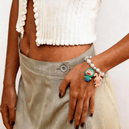 Model wearing a handmade Swarovski crystal charm bracelet with crystals, pearls and retro-inspired collectible charm details