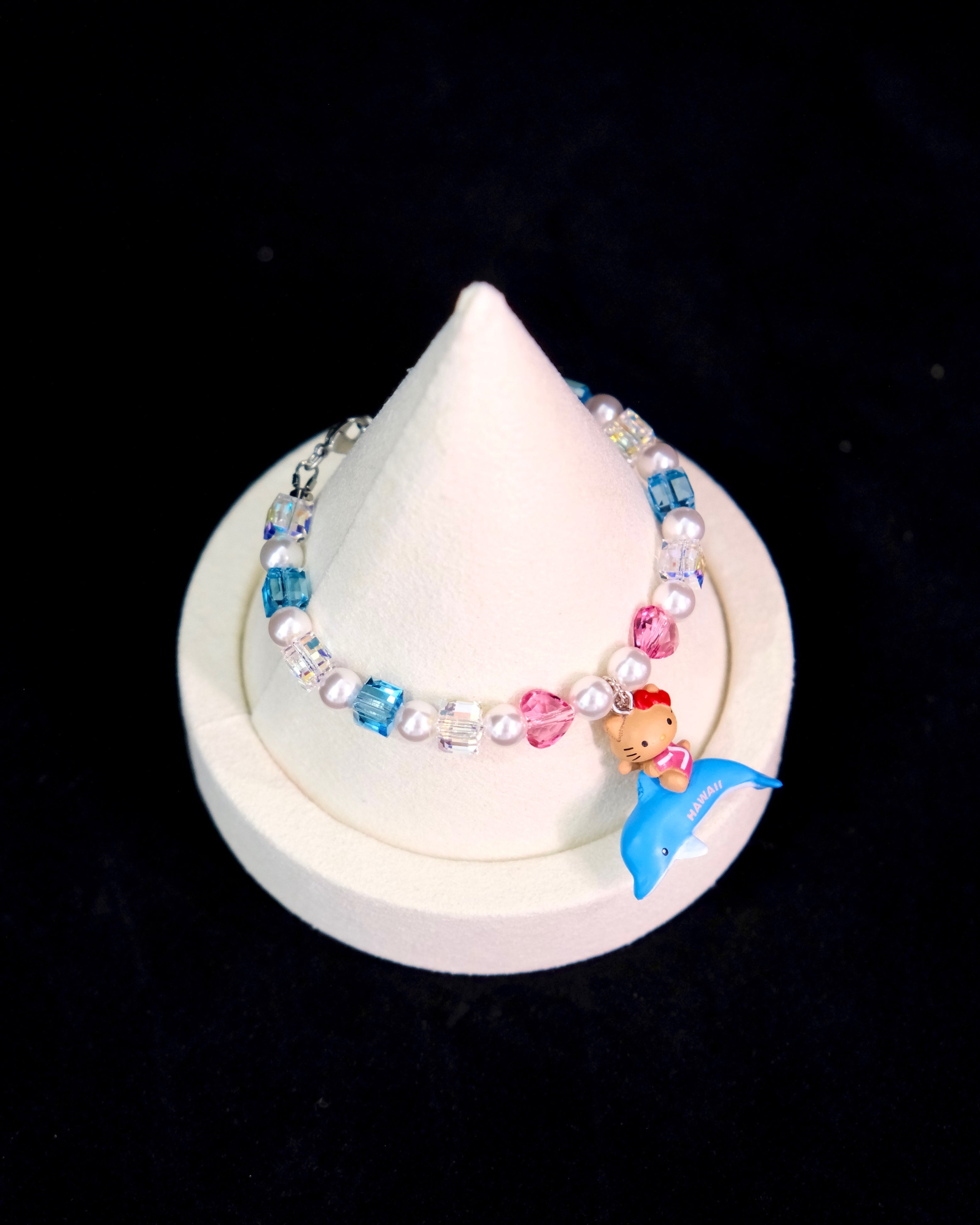 Model wearing a handmade Swarovski crystal charm bracelet with crystals, pearls and surf-inspired collectible charm details