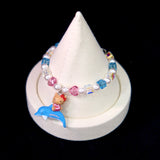 Side view of a handmade Swarovski crystal charm bracelet with layered crystals, pearls and surf-inspired collectible charm details
