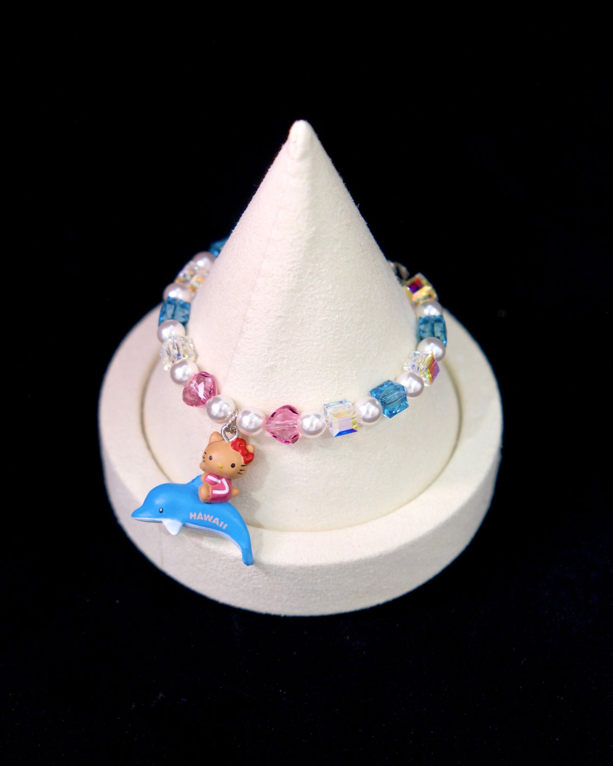 Side view of a handmade Swarovski crystal charm bracelet with layered crystals, pearls and surf-inspired collectible charm details