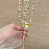 Close-up of a handmade Swarovski crystal charm necklace with crystals, pearls and garden-inspired collectible charm details