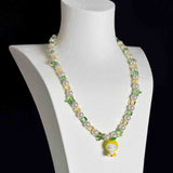 Close-up of a handmade Swarovski crystal charm necklace with crystals, pearls and garden-inspired collectible charm details