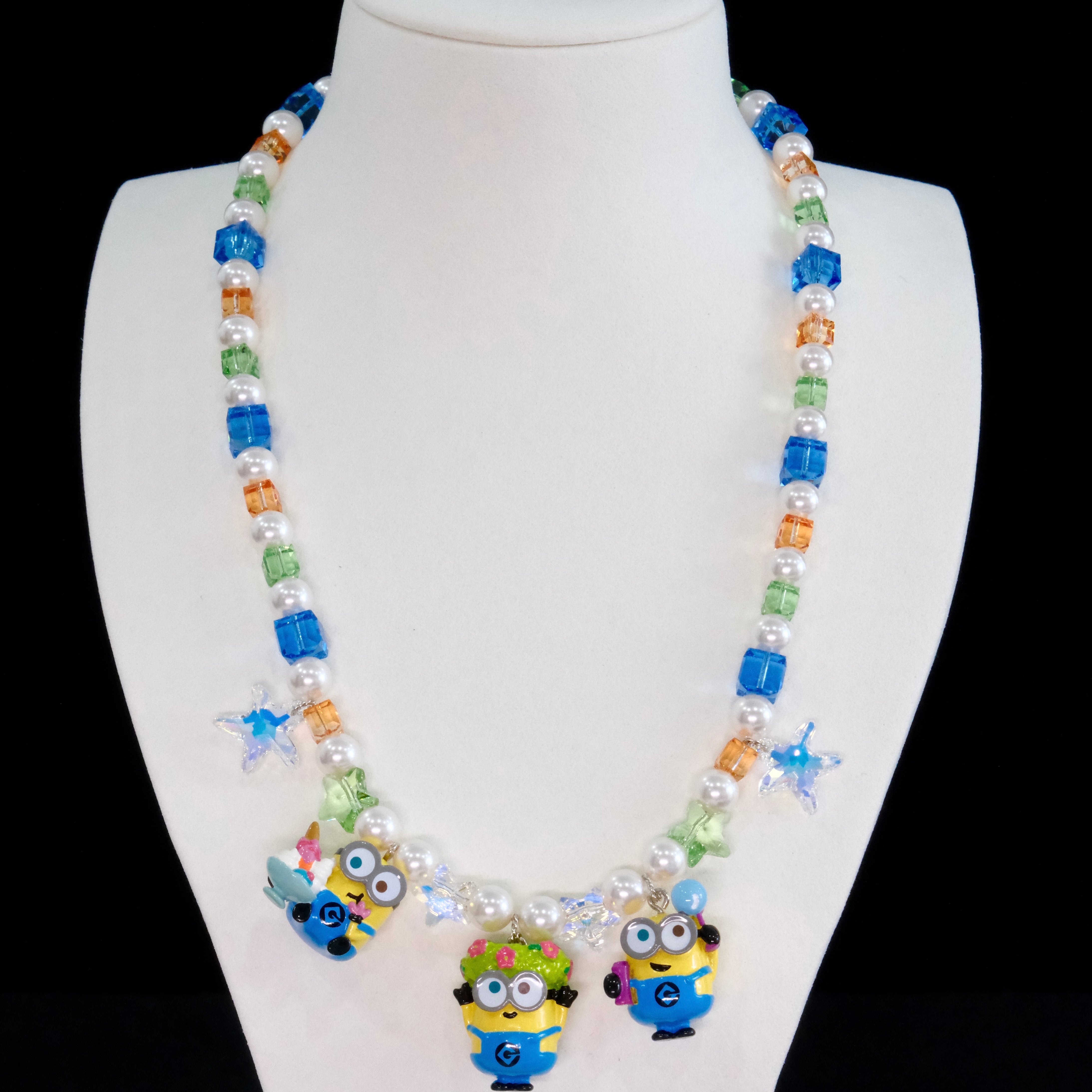 Close-up of a handmade Swarovski crystal charm necklace with crystals, pearls and garden-inspired collectible charm details