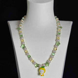 Model wearing a handmade Swarovski crystal charm necklace with crystals, pearls and garden-inspired collectible charm details