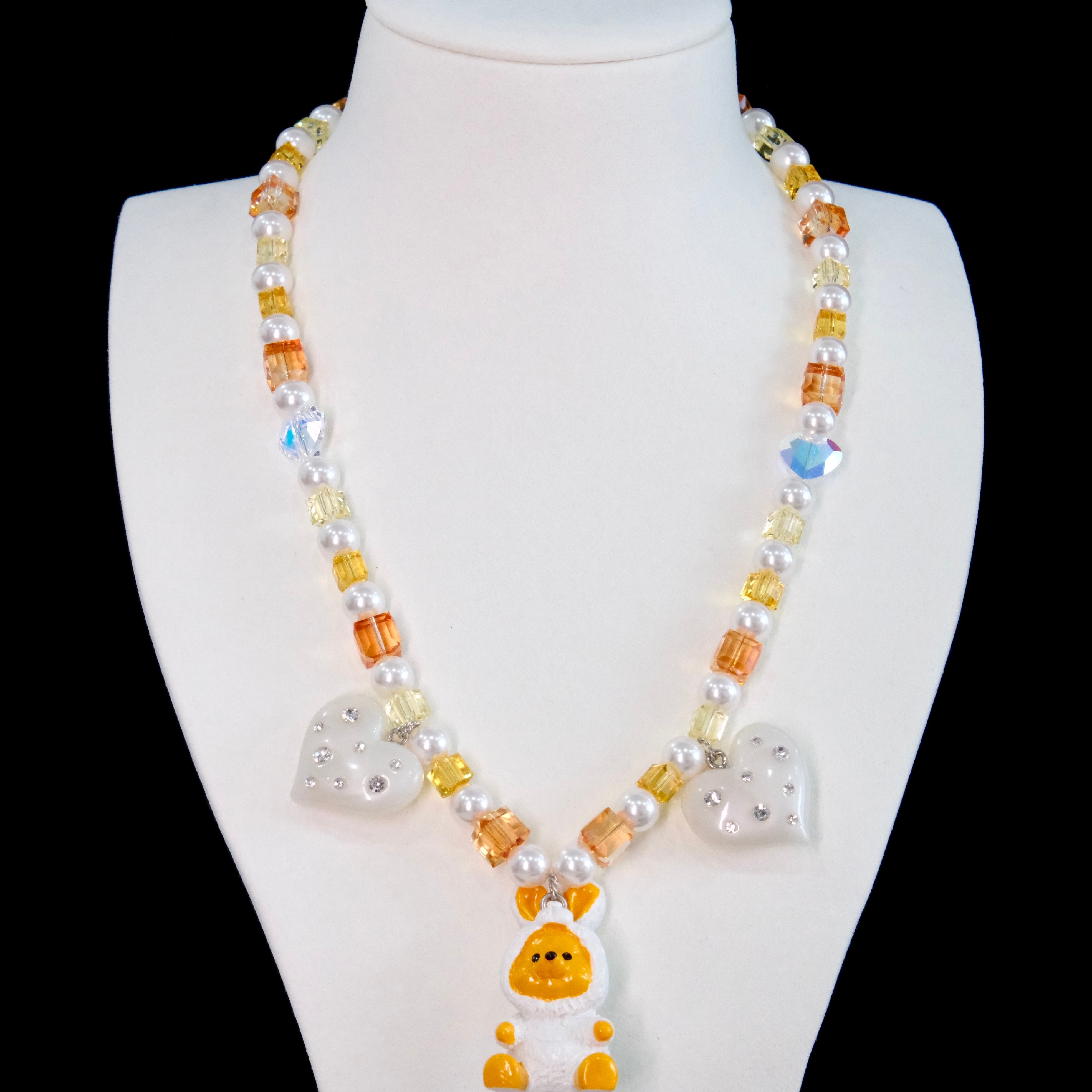 Close-up of a handmade Swarovski crystal charm necklace with crystals, pearls and holiday-inspired collectible charm details