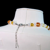 Close-up of a handmade Swarovski crystal charm necklace with crystals, pearls and holiday-inspired collectible charm details