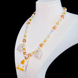 Model wearing a handmade Swarovski crystal charm necklace with crystals, pearls and holiday-inspired collectible charm details