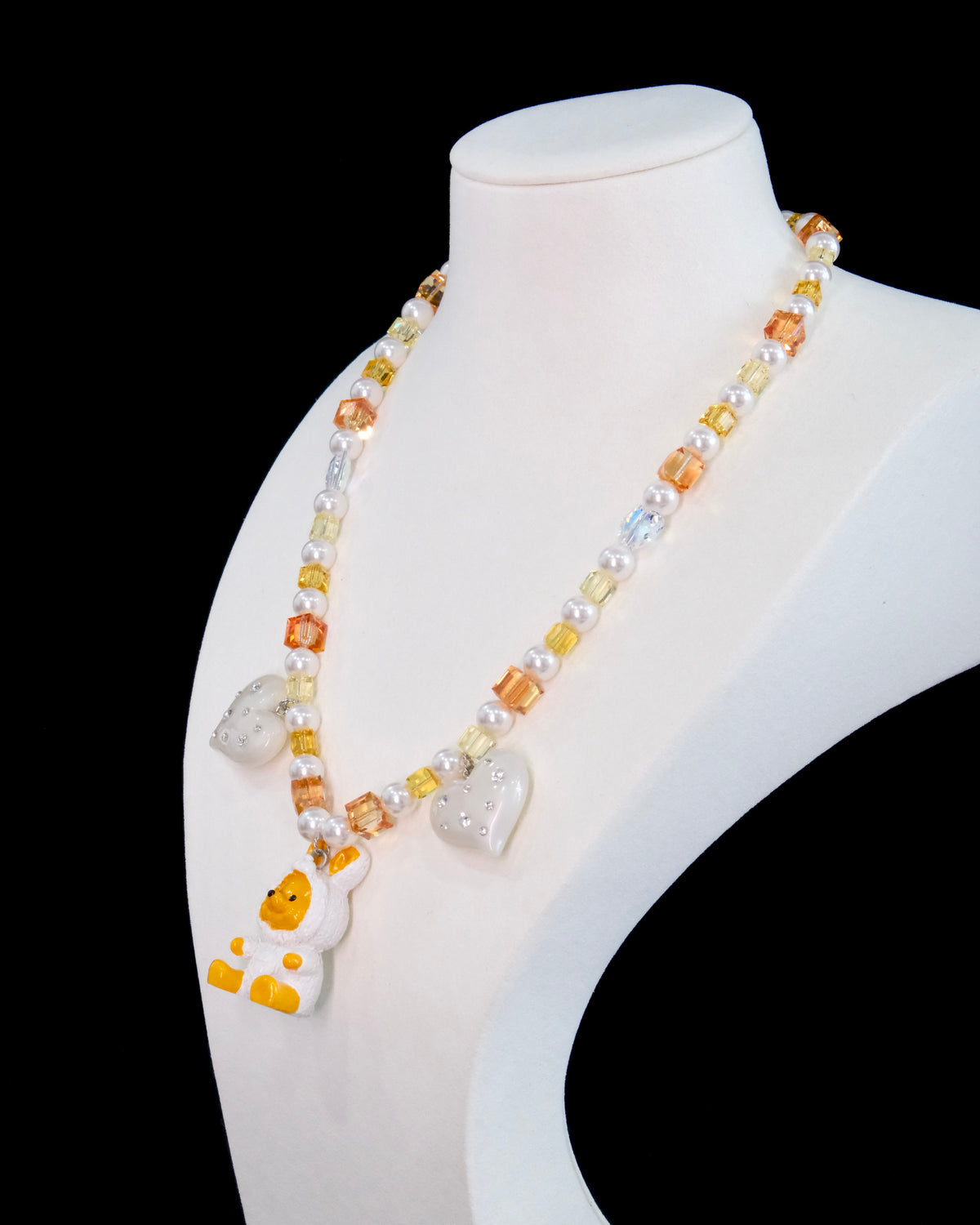 Model wearing a handmade Swarovski crystal charm necklace with crystals, pearls and holiday-inspired collectible charm details