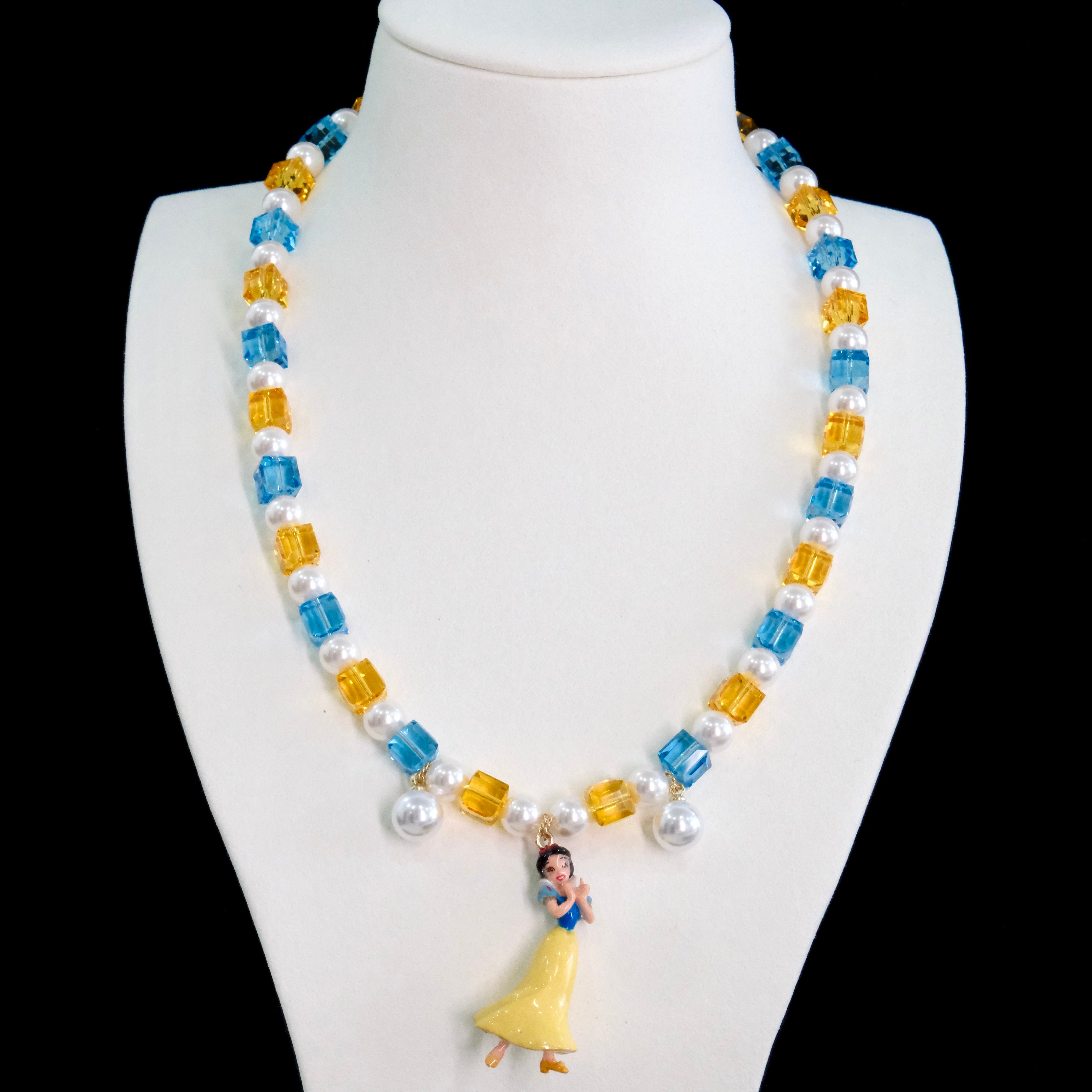 Close-up of a handmade Swarovski crystal charm necklace with crystals, pearls and princess-inspired collectible charm details