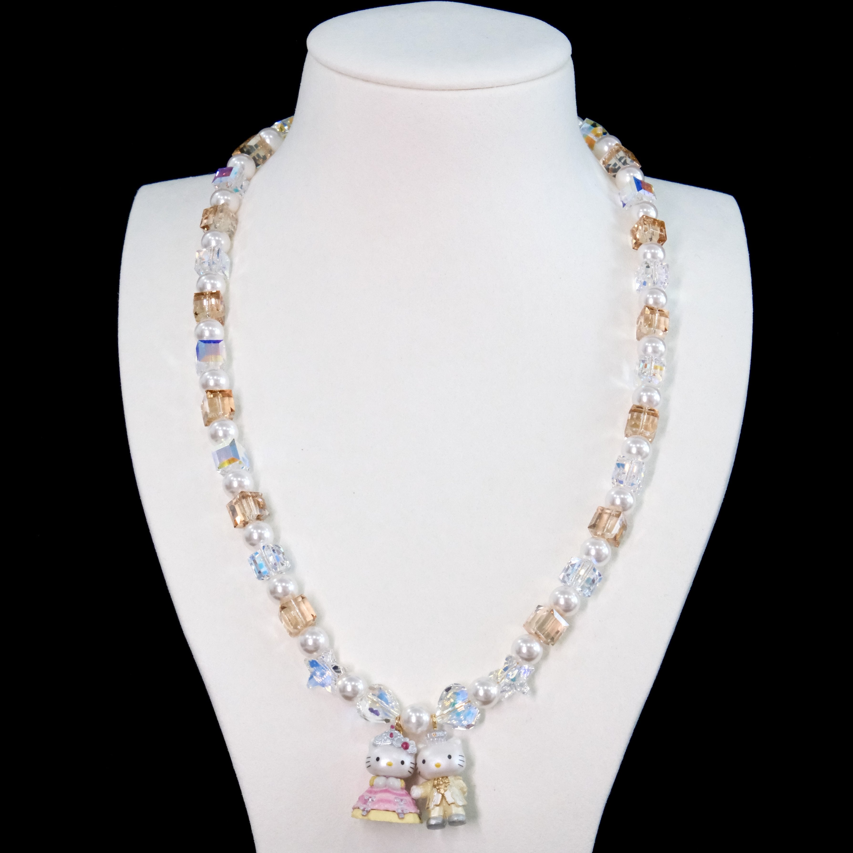 Close-up of a handmade Swarovski crystal charm necklace with crystals, pearls and princess-inspired collectible charm details