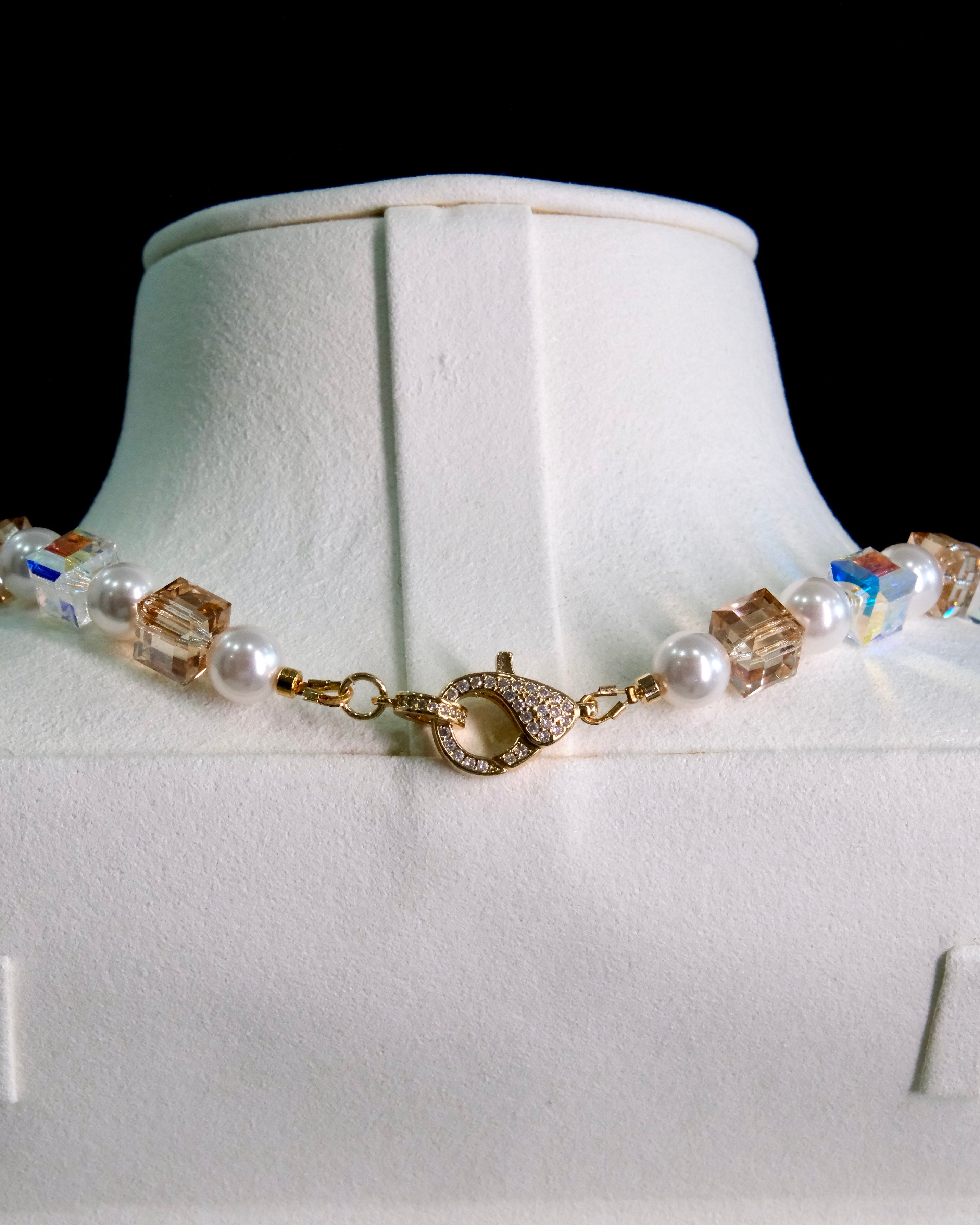 Close-up of a handmade Swarovski crystal charm necklace with crystals, pearls and princess-inspired collectible charm details