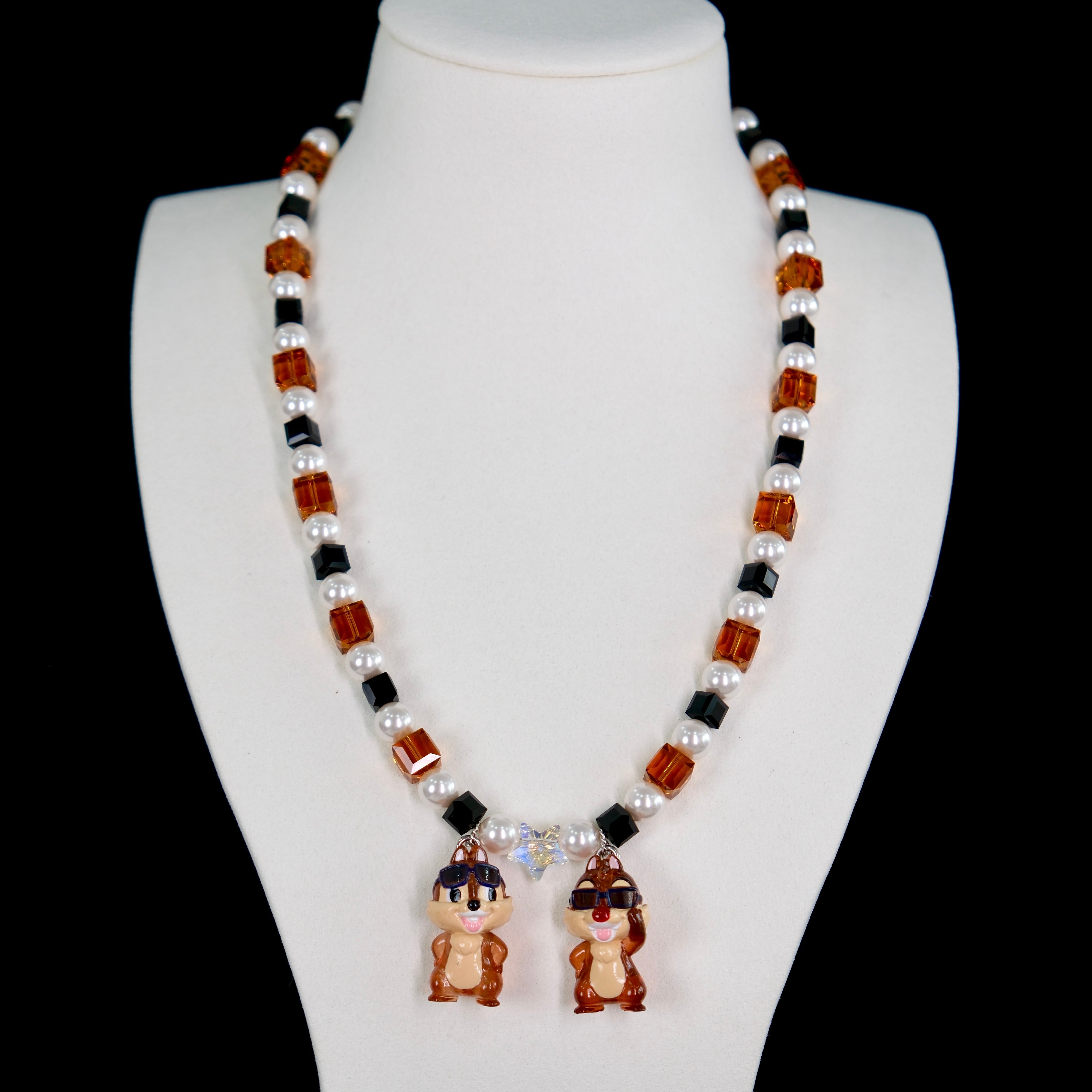 Close-up of a handmade Swarovski crystal charm necklace with crystals, pearls and retro-inspired collectible charm details