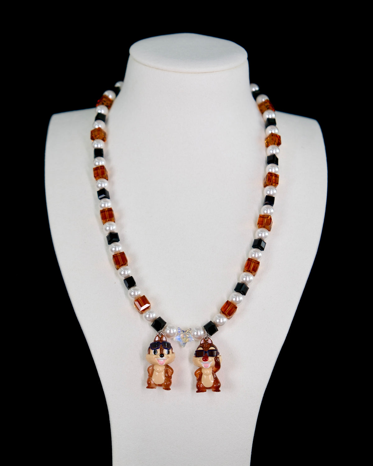 Close-up of a handmade Swarovski crystal charm necklace with crystals, pearls and retro-inspired collectible charm details