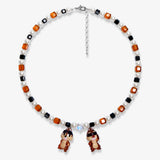 Flat lay of a handmade Swarovski crystal charm necklace with crystals, pearls and retro-inspired collectible charm details