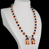 Model wearing a handmade Swarovski crystal charm necklace with crystals, pearls and retro-inspired collectible charm details
