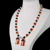 Side view of a handmade Swarovski crystal charm necklace with layered crystals, pearls and retro-inspired collectible charm details
