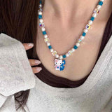Close-up of a handmade Swarovski crystal charm necklace with crystals, pearls and surf-inspired collectible charm details