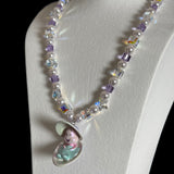 Close-up of a handmade Swarovski crystal charm necklace with crystals, pearls and surf-inspired collectible charm details