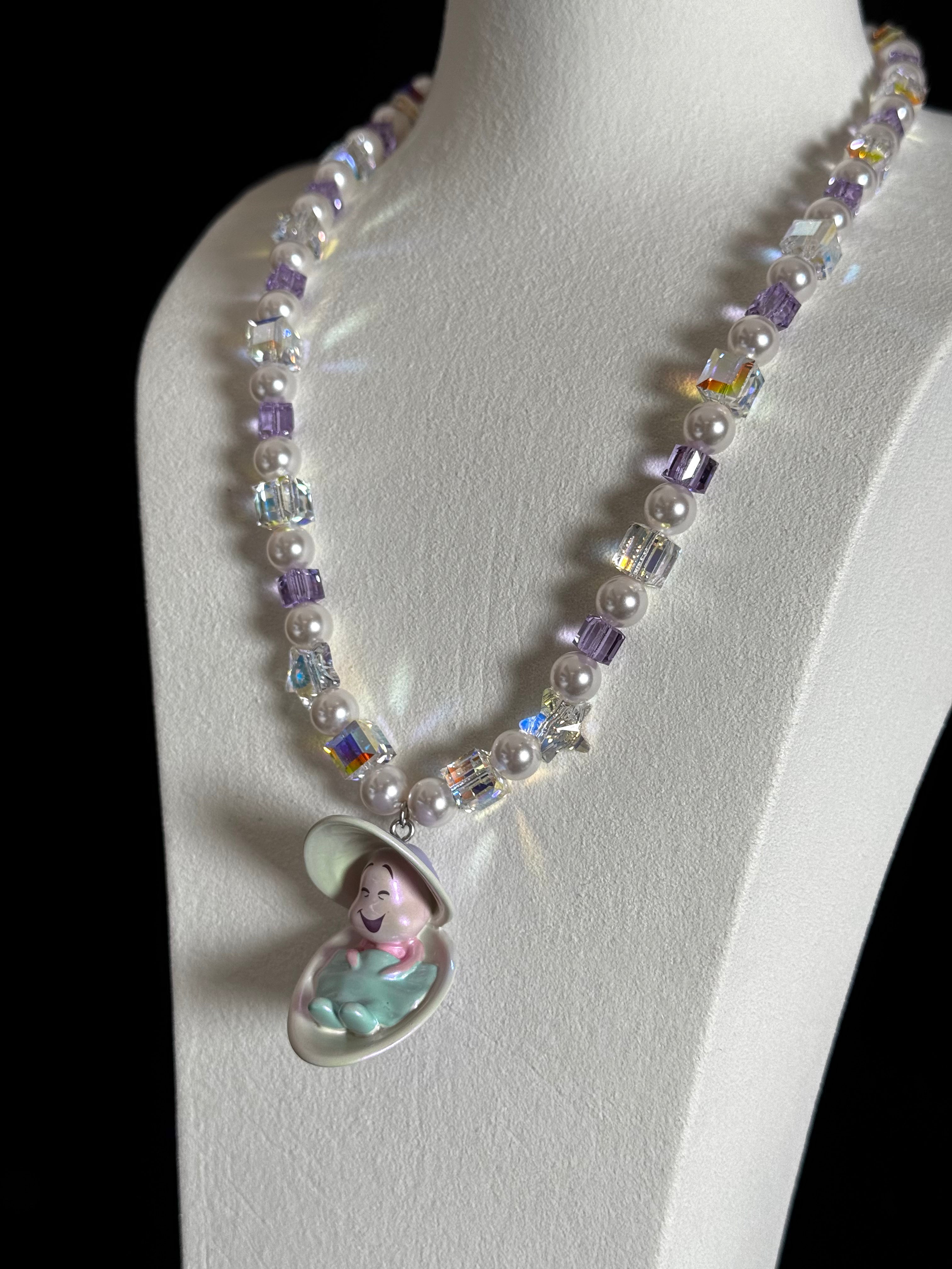 Close-up of a handmade Swarovski crystal charm necklace with crystals, pearls and surf-inspired collectible charm details