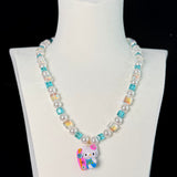 Close-up of a handmade Swarovski crystal charm necklace with crystals, pearls and surf-inspired collectible charm details