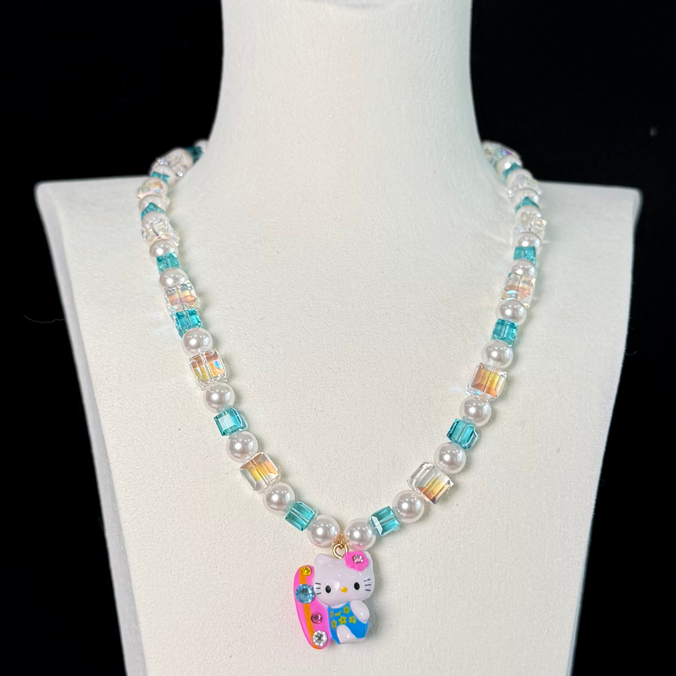 Close-up of a handmade Swarovski crystal charm necklace with crystals, pearls and surf-inspired collectible charm details