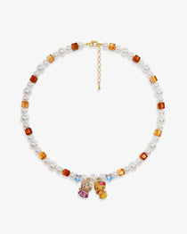 Close-up of a handmade Swarovski crystal charm necklace with crystals, pearls and surf-inspired collectible charm details