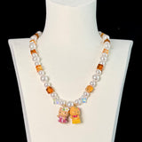 Close-up of a handmade Swarovski crystal charm necklace with crystals, pearls and surf-inspired collectible charm details