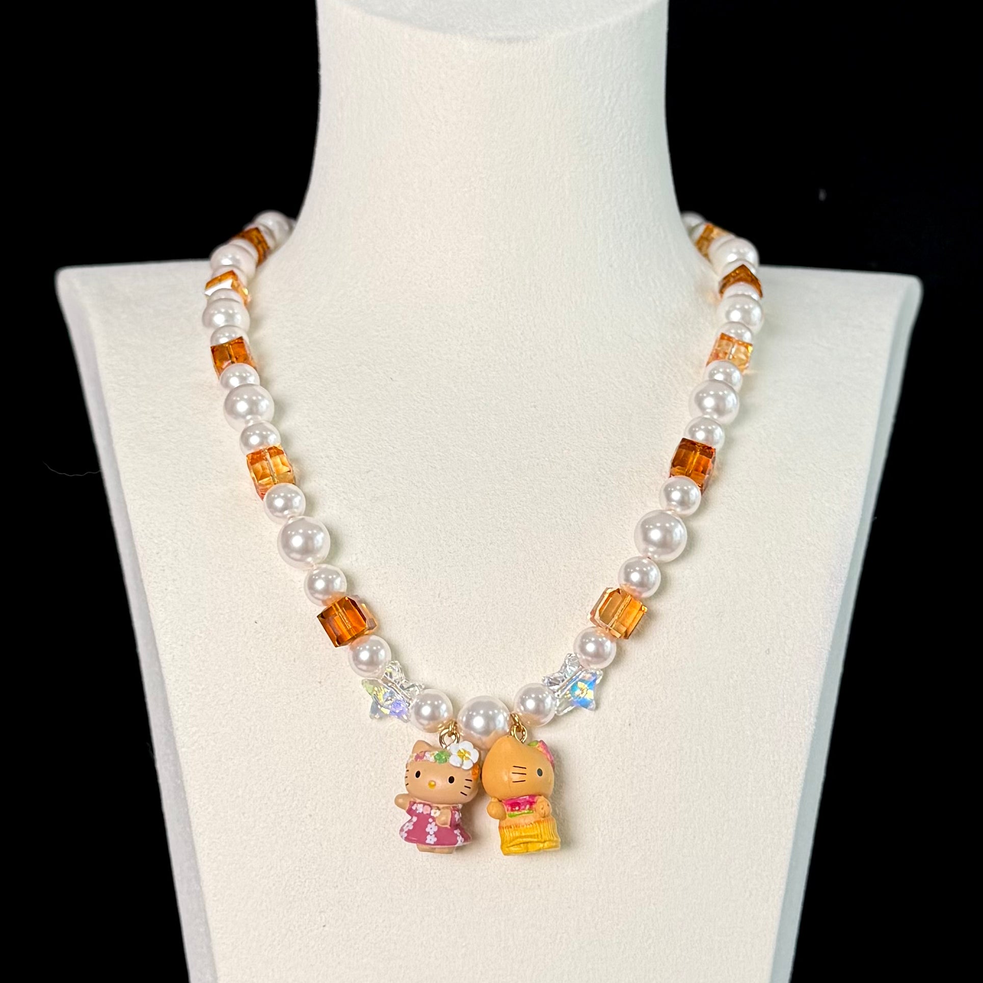 Close-up of a handmade Swarovski crystal charm necklace with crystals, pearls and surf-inspired collectible charm details