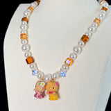 Close-up of a handmade Swarovski crystal charm necklace with crystals, pearls and surf-inspired collectible charm details