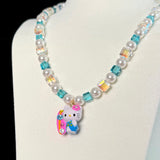 Model wearing a handmade Swarovski crystal charm necklace with crystals, pearls and surf-inspired collectible charm details
