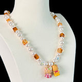 Model wearing a handmade Swarovski crystal charm necklace with crystals, pearls and surf-inspired collectible charm details