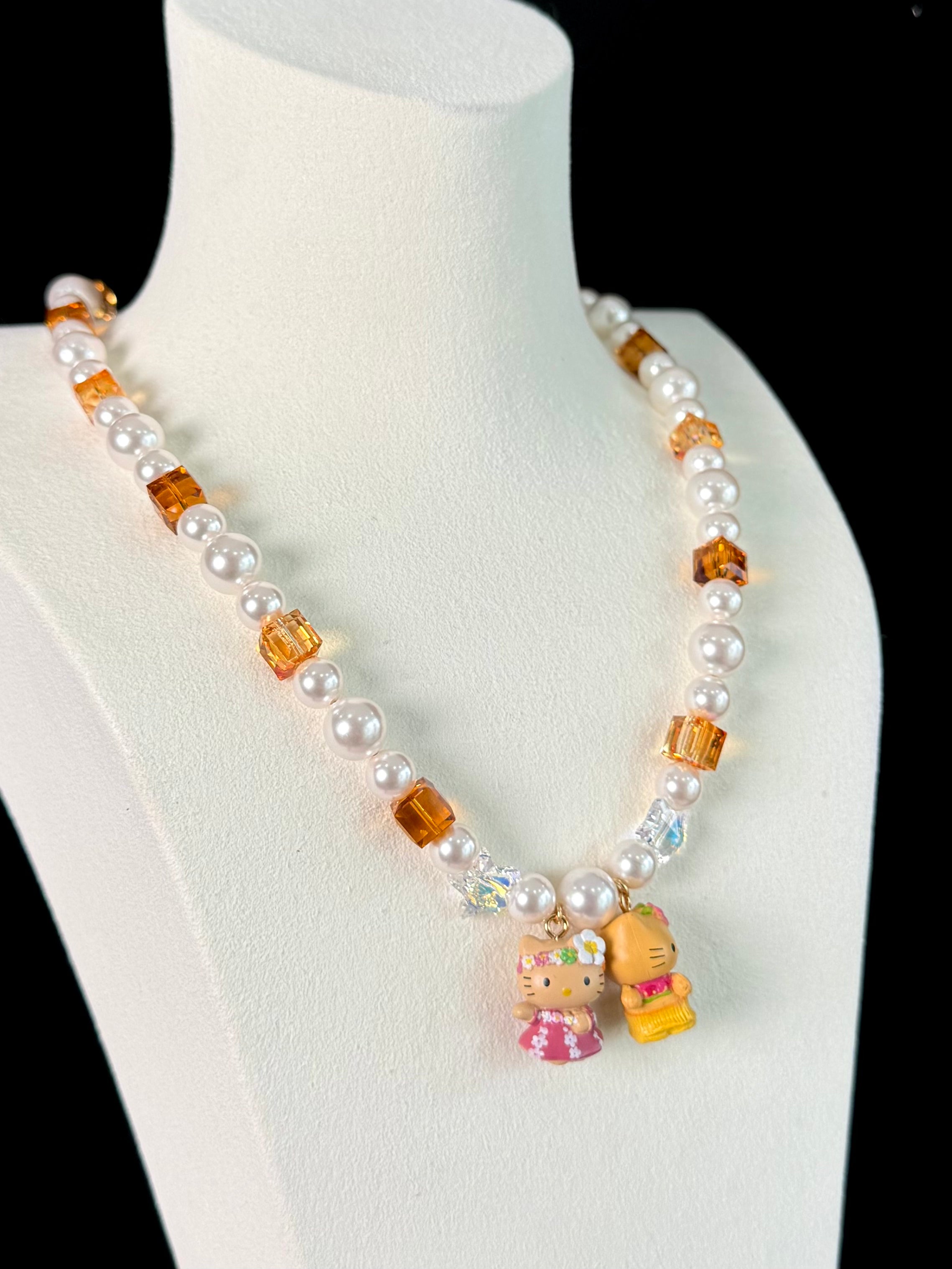 Model wearing a handmade Swarovski crystal charm necklace with crystals, pearls and surf-inspired collectible charm details