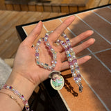 Model wearing a handmade Swarovski crystal charm necklace with crystals, pearls and surf-inspired collectible charm details