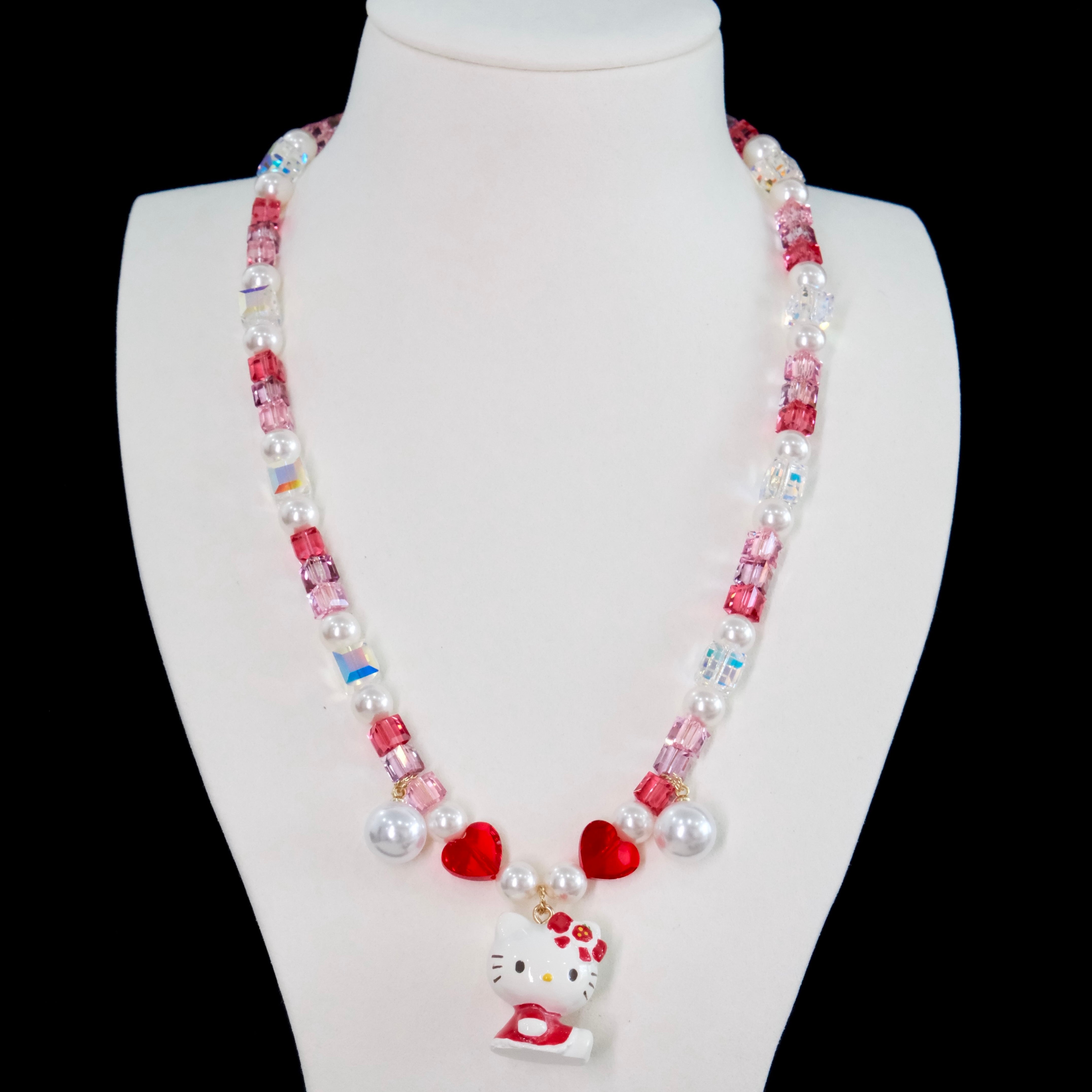 Close-up of a handmade Swarovski crystal charm necklace with crystals, pearls and sweetheart-inspired collectible charm details