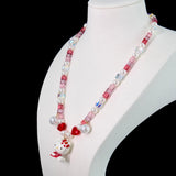Model wearing a handmade Swarovski crystal charm necklace with crystals, pearls and sweetheart-inspired collectible charm details
