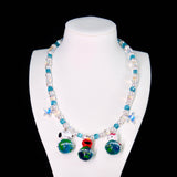 Close-up of a handmade Swarovski crystal charm necklace with crystals, pearls and travel-inspired collectible charm details