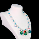 Close-up of a handmade Swarovski crystal charm necklace with crystals, pearls and travel-inspired collectible charm details