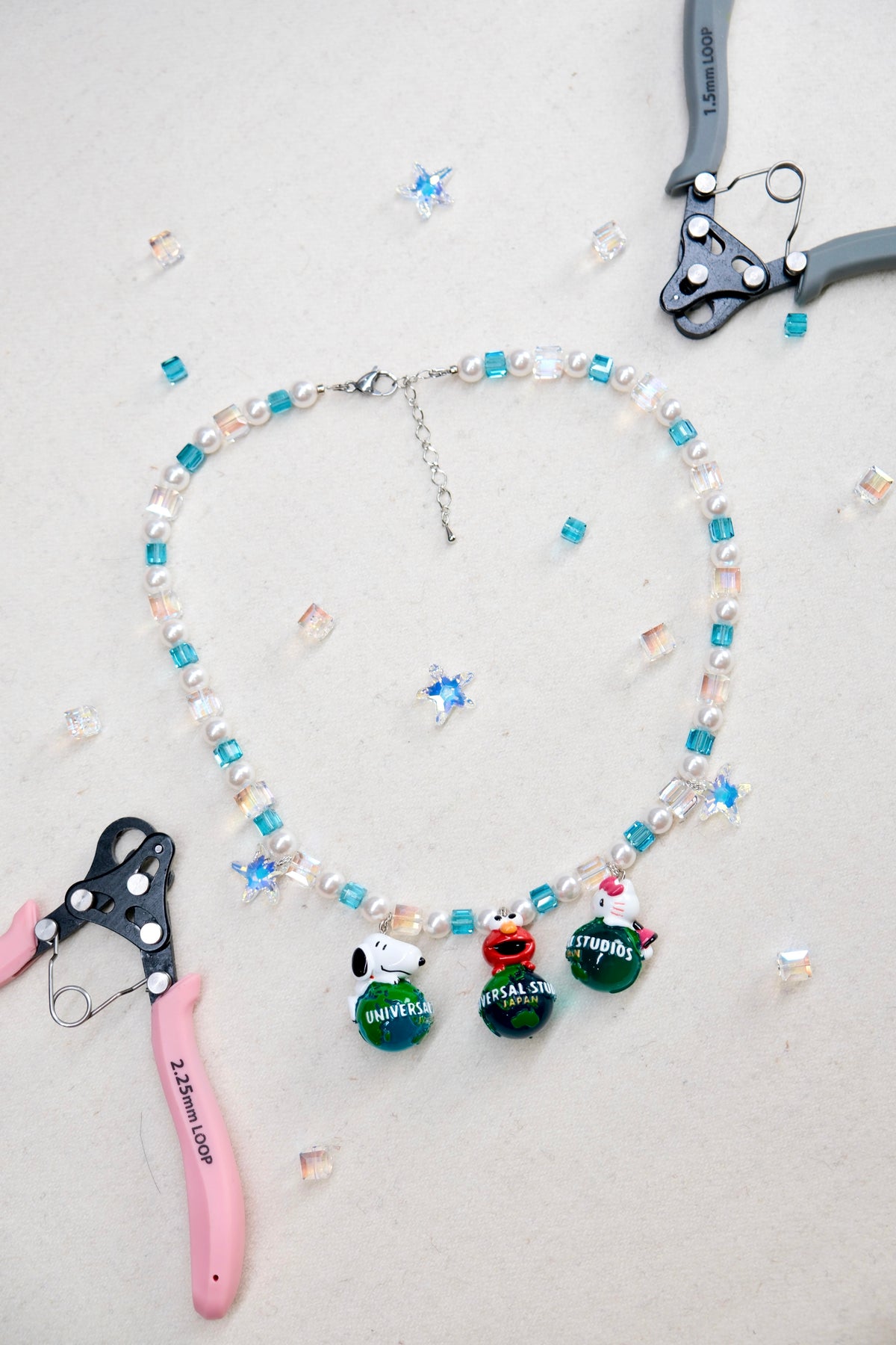 Close-up of a handmade Swarovski crystal charm necklace with crystals, pearls and travel-inspired collectible charm details